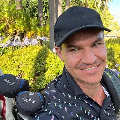Todd Molloy in a cap beside his golf bag